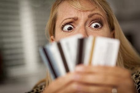 Credit Card Debt: Upset Woman Glaring At Her Many Credit Cards.