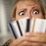 Credit Card Debt: Upset Woman Glaring At Her Many Credit Cards.