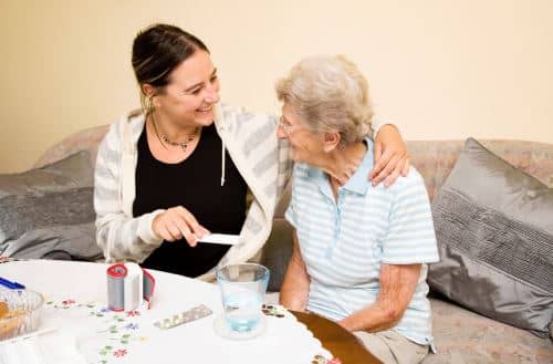 Young Lady Giving Care to Elderly Woman