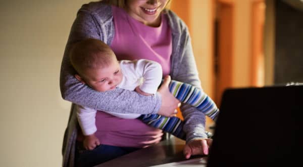 Mom Reading a Newsletter While Holding Child